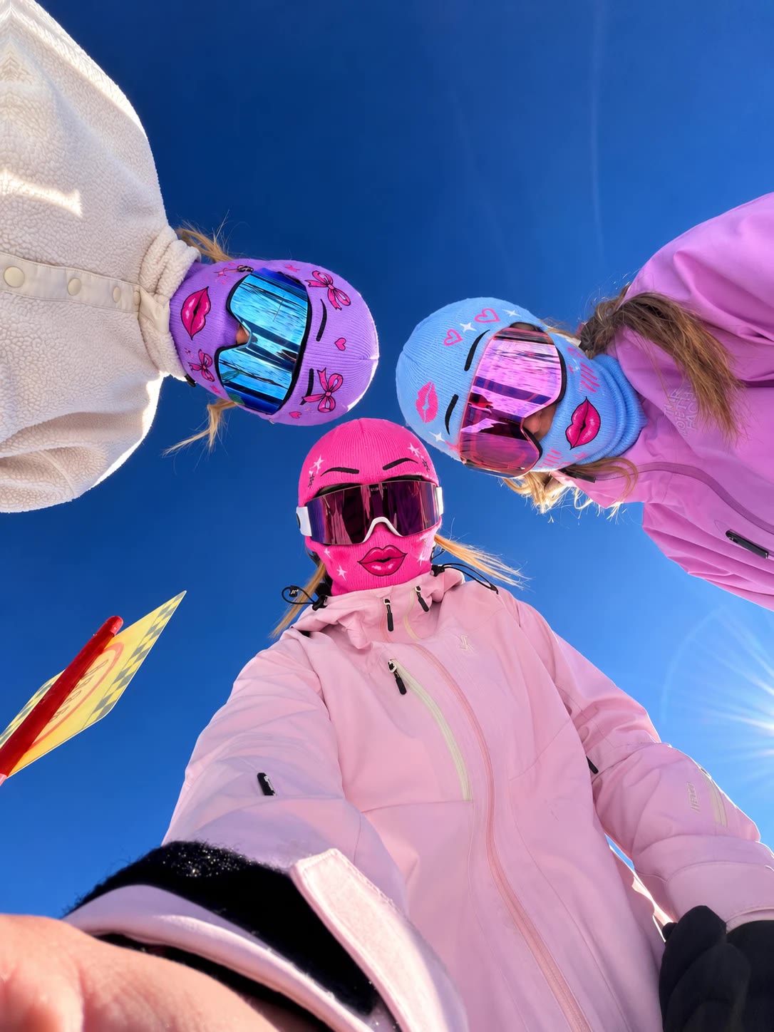 Trois amies en cagoules glam vues d'en bas, ciel bleu